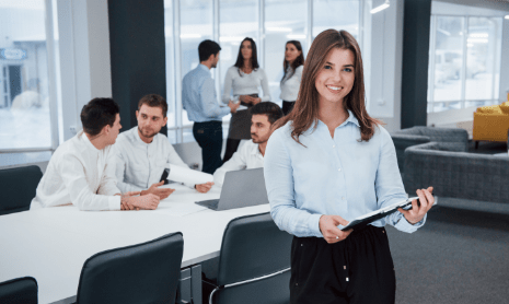 feels-good-because-she-loves-she-s-job-portrait-young-girl-stands-office-with-employees-background-min